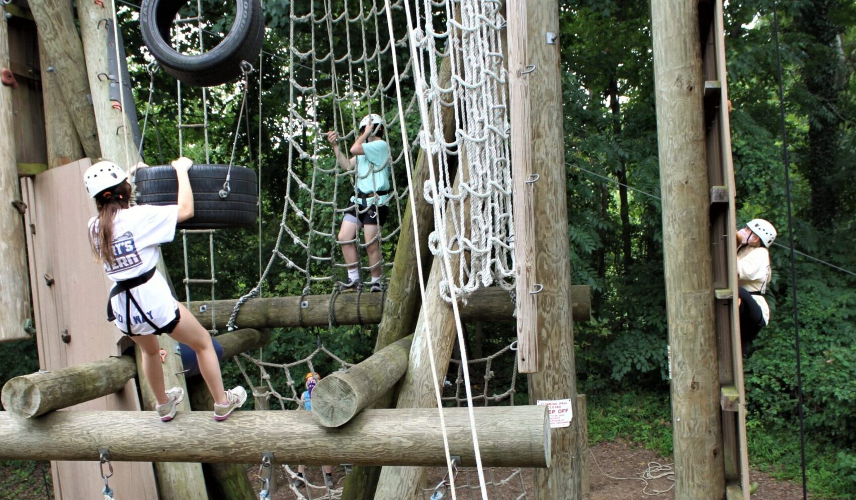 Three campers scale different sections of climbing apparatus while participating in Camp Phoenix Teen Grief Camp Aug. 15 at Terrapin Adventures in Savage, Maryland.