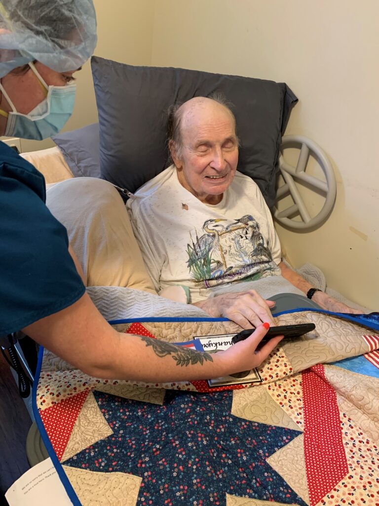 Registered Nurse Case Manager Kelly Brennan plays the video of active-duty military volunteers thanking veterans for their service during Bert Behringer’s virtual honor salute at Morningside House of Friendship. The virtual salute was created as Hospice of the Chesapeake's response pandemic restrictions. 