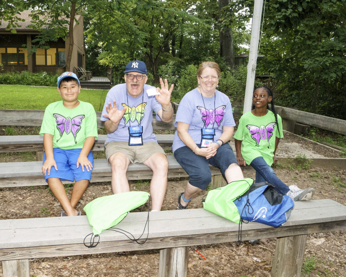 Two counselors and two kids on benches at Camp Nabi grief camp