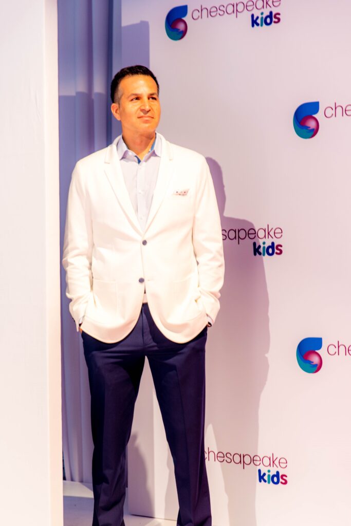 Emcee Bryan Nehman stands on the runway of the 2022 Fashion for a Cause fundraiser