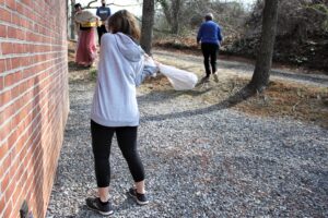 A Smash and Mend Healing Retreat participant slams a bag filled with ceramics against a wall. By Elyzabeth Marcussen, Hospice of the Chesapeake