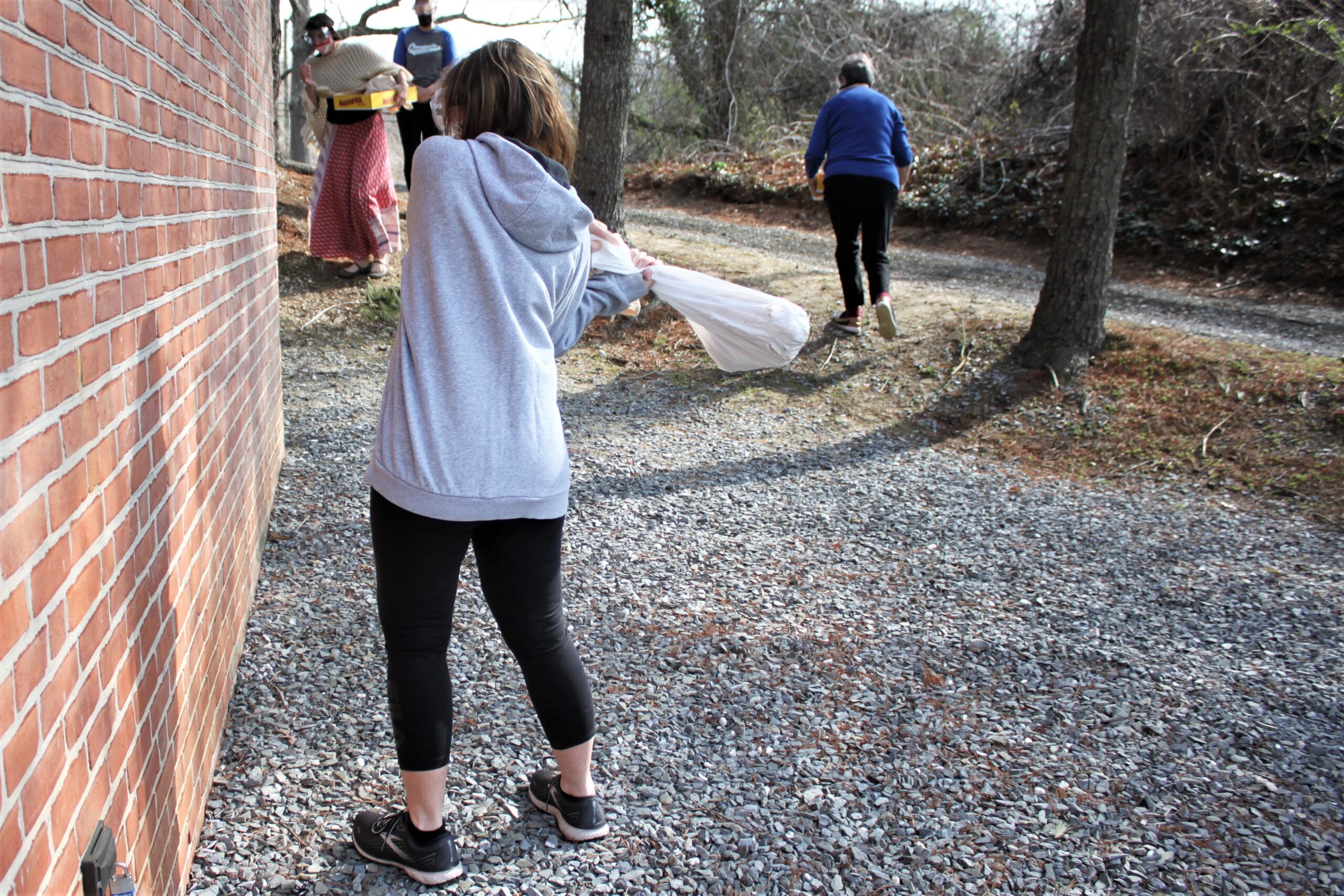 A Smash and Mend Healing Retreat participant slams a bag filled with ceramics against a wall. By Elyzabeth Marcussen, Hospice of the Chesapeake