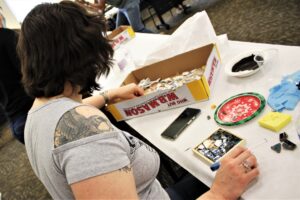 A Smash and Mend Healing Retreat participant takes broken pieces of ceramics to create a mosaic.